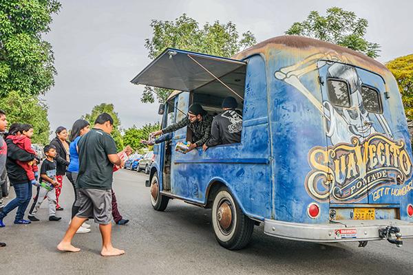 People receiving gifts from the Suavecito Metro Van